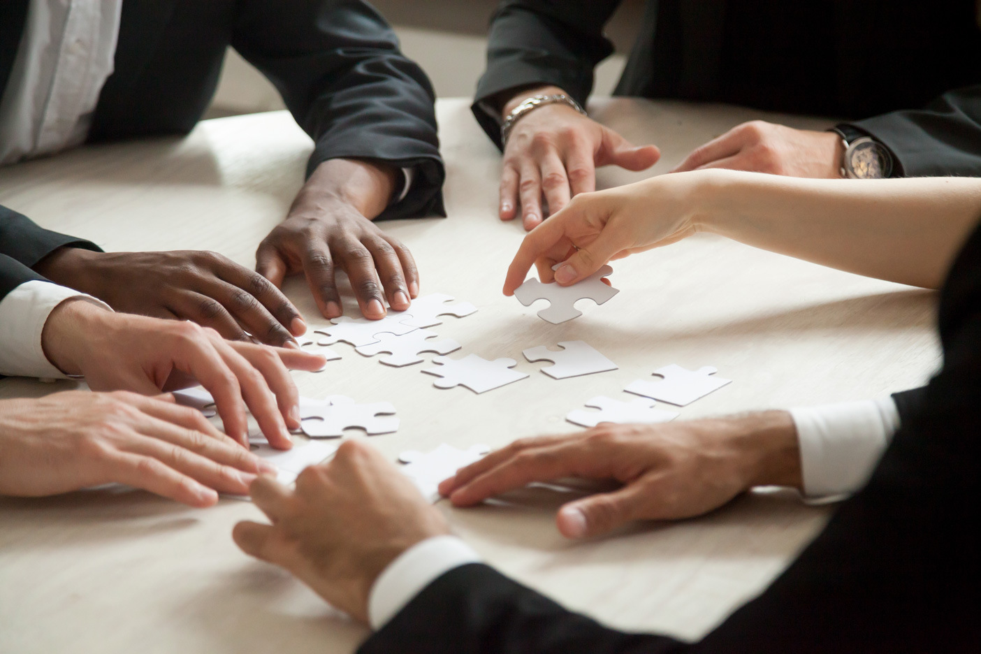 close-up-multiethnic-team-solving-blank-puzzle-game